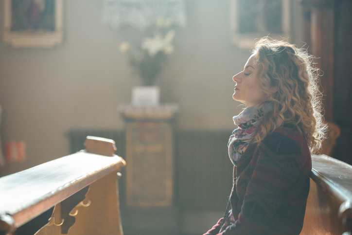 Woman breathing deeply in church.