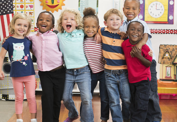 Happy kids gathered together in a classroom.
