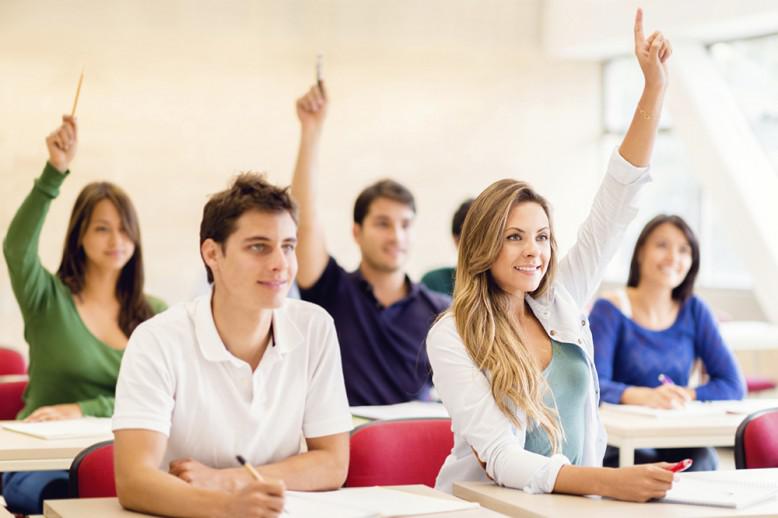 kids in classroom raising their hands