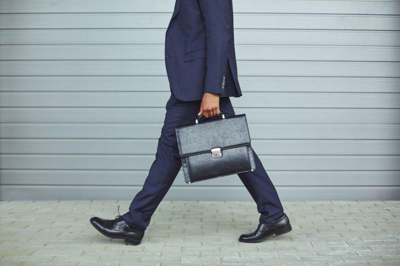 Business man walks on the street with brief case