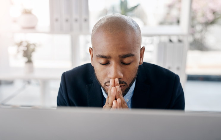 Businessman praying in office
