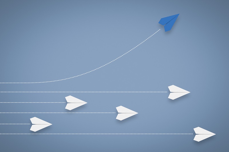 A Paper airplane changing direction from other paper airplanes