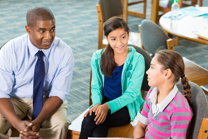 two teachers talking with a student who has been bullied