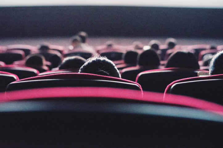 Chairs with people watching a movie in the theater