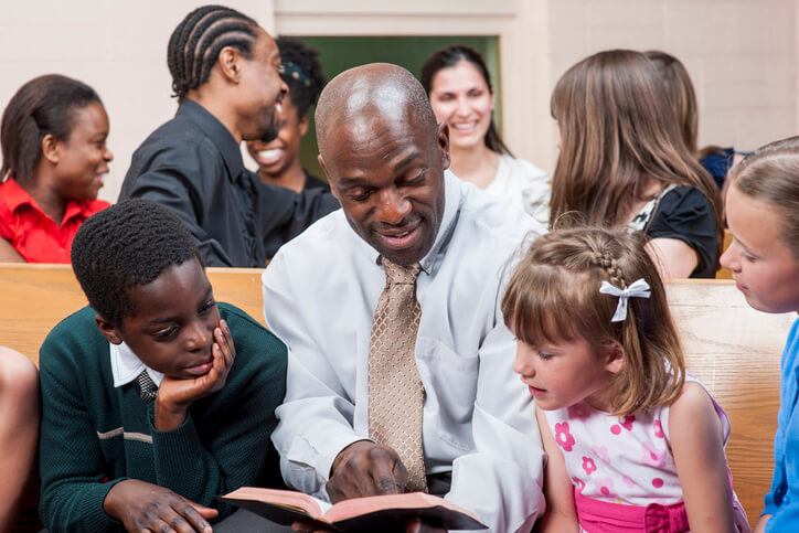 Man teaches children a Bible story as his Christian vocation
