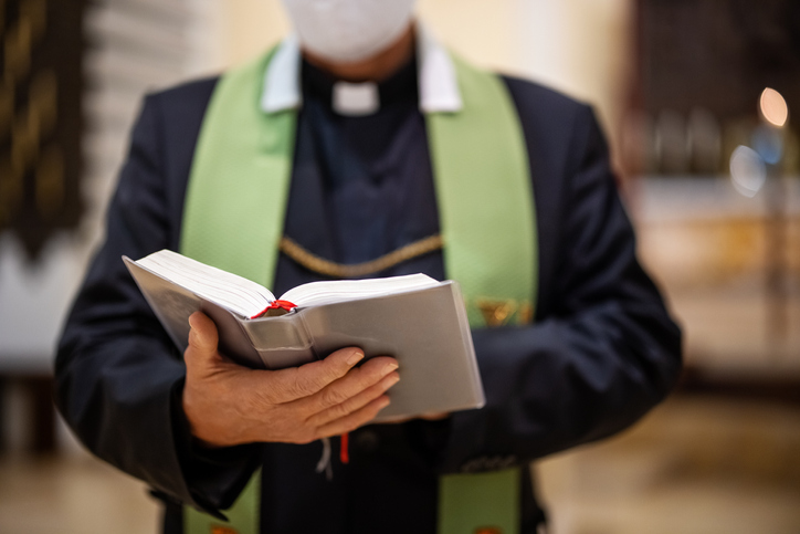 priest reading bible during congregation 