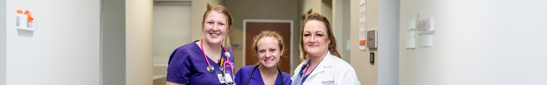 Two female nursing students and female GCU nursing instructor smile in hospital